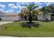 Inviting home with a lush lawn, mature palm trees, and an attached two-car garage at 388 Orlando Blvd, Port Charlotte, FL 33954