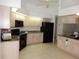 Bright kitchen features ample cabinetry, sleek black appliances, and tiled flooring for easy maintenance at 388 Orlando Blvd, Port Charlotte, FL 33954