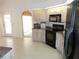 Corner view of the kitchen showcasing the black appliances and cabinetry, with access to the sunroom at 388 Orlando Blvd, Port Charlotte, FL 33954