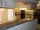 Open layout from the kitchen showcasing granite countertops, breakfast bar, and seamless flow to the living area at 388 Orlando Blvd, Port Charlotte, FL 33954