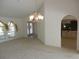 Open living room boasts bright windows, a chandelier, and access to kitchen, creating an inviting atmosphere at 388 Orlando Blvd, Port Charlotte, FL 33954