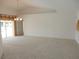Spacious living room with neutral carpet, high ceilings, and sliding glass doors leading to the exterior at 388 Orlando Blvd, Port Charlotte, FL 33954