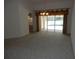 Open living room with neutral carpet, decorative lighting, and access to the outdoor pool area at 388 Orlando Blvd, Port Charlotte, FL 33954