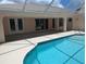 Serene view of the screened-in pool, showcasing direct access to the house through sliding glass doors at 388 Orlando Blvd, Port Charlotte, FL 33954