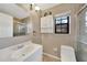 Neutral bathroom with a white cabinet, toilet, sink, and shower featuring a window at 4062 Blitzen Ter, North Port, FL 34287