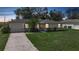 Charming home featuring a lush green lawn, mature trees, and a well-lit exterior at twilight at 4062 Blitzen Ter, North Port, FL 34287