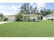 Charming single-story home with lush green lawn and mature landscaping, creating an inviting curb appeal at 4062 Blitzen Ter, North Port, FL 34287