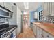Galley-style kitchen features stainless steel appliances, white cabinets, and a long hallway view at 4062 Blitzen Ter, North Port, FL 34287