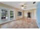Spacious living room with tiled floors, ceiling fan, and french doors providing access to lanai at 4062 Blitzen Ter, North Port, FL 34287