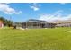 Expansive backyard with a screened-in pool and a well, surrounded by well-manicured lawn at 4123 Rock Creek Dr, Port Charlotte, FL 33948