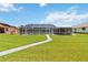 Backyard featuring a screened-in pool and lush green lawn, great for outdoor entertainment and relaxation at 4123 Rock Creek Dr, Port Charlotte, FL 33948