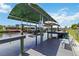 Private boat dock and lift on the canal with a gray wood deck and a green sunshade at 4123 Rock Creek Dr, Port Charlotte, FL 33948