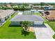 Waterfront home with a well-manicured lawn, mature palm tree, and a screened lanai for seamless indoor-outdoor living at 4123 Rock Creek Dr, Port Charlotte, FL 33948