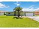 Charming home with a lush lawn and a mature palm tree, creating a welcoming and tropical curb appeal at 4123 Rock Creek Dr, Port Charlotte, FL 33948