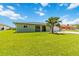 Charming single-story home with a well-manicured lawn and a mature palm tree at 4123 Rock Creek Dr, Port Charlotte, FL 33948