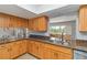 Well-lit kitchen with wood cabinets, granite countertops, and a double sink at 4123 Rock Creek Dr, Port Charlotte, FL 33948