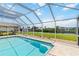 Enjoy the screened-in pool with water views and lush green landscaping in this backyard oasis at 4123 Rock Creek Dr, Port Charlotte, FL 33948