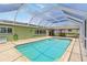 This screened-in pool area features stone tile, a fish decoration on the wall, and plenty of room for entertaining at 4123 Rock Creek Dr, Port Charlotte, FL 33948