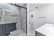 Bathroom with a tiled shower, glass door, marble floors, and a white vanity at 4244 Harbor Blvd, Port Charlotte, FL 33952