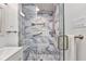 Bathroom featuring a glass shower with marble-style tile, niche, grab bar, and modern fixtures at 4244 Harbor Blvd, Port Charlotte, FL 33952