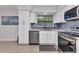 Bright kitchen featuring white cabinets, stainless appliances, and a view to a storage room at 4244 Harbor Blvd, Port Charlotte, FL 33952