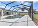 Enclosed pool area with covered patio, dining table, and lounge chairs at 4244 Harbor Blvd, Port Charlotte, FL 33952