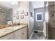 Well-lit bathroom featuring a granite countertop, large mirror, and tiled shower at 437 South Dr, Punta Gorda, FL 33950