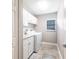 Laundry room featuring stone floors, cabinets, a window with blinds, and a washer and dryer at 437 South Dr, Punta Gorda, FL 33950