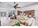 Open-concept living area with travertine flooring, a ceiling fan, and seamless flow into the gourmet kitchen at 437 South Dr, Punta Gorda, FL 33950