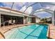 Sparkling pool surrounded by brick pavers, outdoor seating, and a screened enclosure at 437 South Dr, Punta Gorda, FL 33950