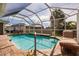 Screened in pool with brick decking, a lounge chair, and lush landscaping at 437 South Dr, Punta Gorda, FL 33950