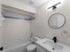 Bathroom featuring a shower-tub combo, round mirror, updated vanity and black fixtures at 464 Rose Apple Cir, Port Charlotte, FL 33954