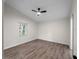 Bright bedroom featuring wood-look flooring, ceiling fan, and one window at 464 Rose Apple Cir, Port Charlotte, FL 33954
