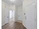 Bright hallway with wood flooring and multiple entry doors showcasing the home's layout at 464 Rose Apple Cir, Port Charlotte, FL 33954