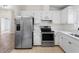 Well-lit kitchen with stainless steel refrigerator, modern appliances, and ample counter space at 464 Rose Apple Cir, Port Charlotte, FL 33954