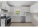 Bright kitchen featuring white cabinetry, stainless steel appliances, and a window view at 464 Rose Apple Cir, Port Charlotte, FL 33954