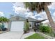 Charming home featuring a light green exterior, a one-car garage, and a cozy front porch at 477 Ricold Ter, Port Charlotte, FL 33954