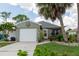Charming home featuring a light green exterior, a one-car garage, and a cozy front porch at 477 Ricold Ter, Port Charlotte, FL 33954