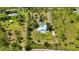 Beautiful aerial view of a secluded light blue home with backyard pool, fenced yard and circular driveway at 5950 Cypress Grove Cir, Punta Gorda, FL 33982