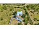 Stunning aerial view of a light blue home on acreage with lush landscaping, long driveway and a fenced yard at 5950 Cypress Grove Cir, Punta Gorda, FL 33982