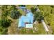 Detailed aerial view of a home with a blue roof, showcasing the pool, well-kept lawn, and surrounding outbuildings at 5950 Cypress Grove Cir, Punta Gorda, FL 33982