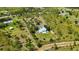 Wide aerial view of a private estate with a home, outbuilding and manicured lawn surrounded by a beautiful landscape at 5950 Cypress Grove Cir, Punta Gorda, FL 33982