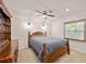 Comfortable bedroom with a wooden bed frame, ceiling fan, and bright natural light at 5950 Cypress Grove Cir, Punta Gorda, FL 33982