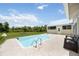 Backyard pool with metal ladder, surrounded by a stamped concrete patio and open lawn at 5950 Cypress Grove Cir, Punta Gorda, FL 33982
