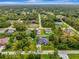 Aerial view of home surrounded by lush trees, on a verdant street at 6444 Alhambra Ave, North Port, FL 34291