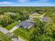 Aerial view of a home surrounded by lush trees, featuring a pool at 6444 Alhambra Ave, North Port, FL 34291