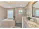 Bright bathroom featuring a soaking tub, a stand-up shower with decorative tile, and stylish granite countertops at 6444 Alhambra Ave, North Port, FL 34291