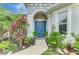 Inviting front entrance with vibrant blue double doors and lush tropical plants at 6444 Alhambra Ave, North Port, FL 34291