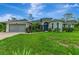 Charming single-story home with lush landscaping and a well-manicured lawn at 6444 Alhambra Ave, North Port, FL 34291