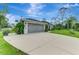 View of a modern home's garage and driveway, complemented by simple landscaping at 6444 Alhambra Ave, North Port, FL 34291